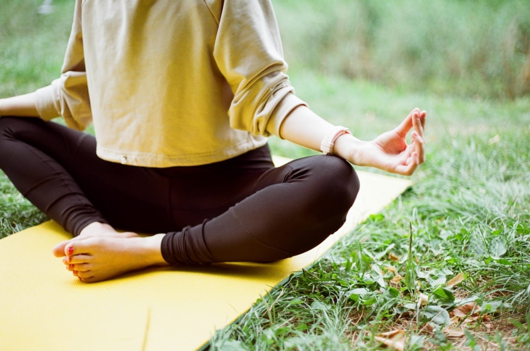 Copro di donna che fa Yoga su prato